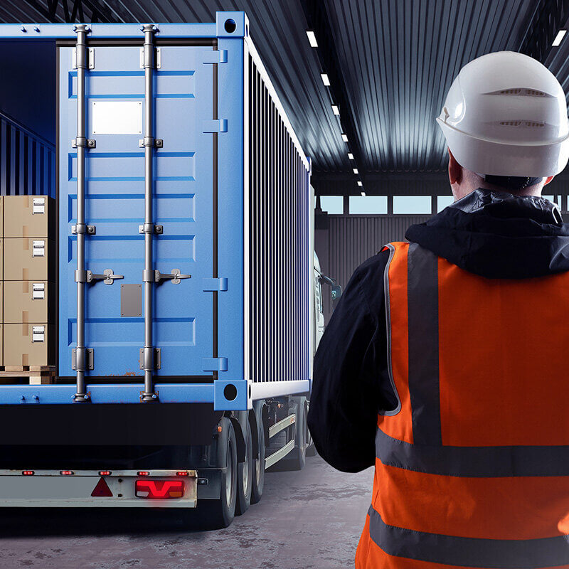 worker looking at pallet of items inside a container truck